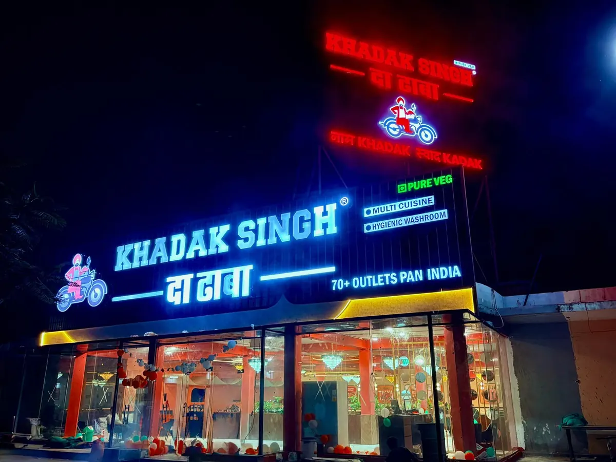 Khadak Singh Da Dhaba pure veg restaurant lit up at night at Pinan Rest Area, Delhi–Mumbai Expressway